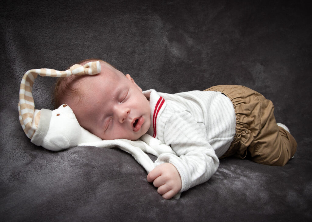 Photographie d'un bébé qui dort avec son doudou en Alsace