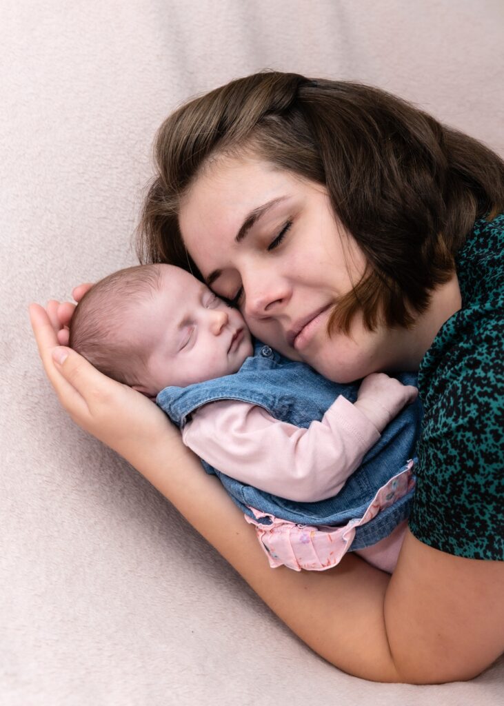 Photographie tendre d'un bébé avec sa maman qui lui fait un câlin dans le Haut-Rhin