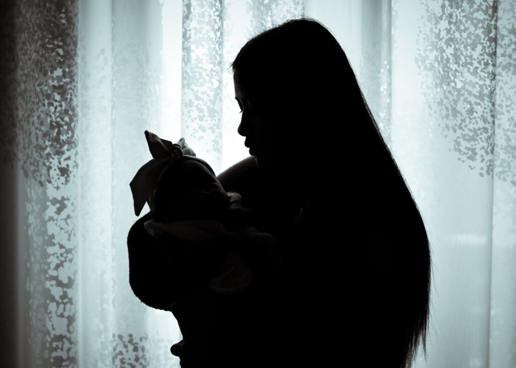 Photographie portrait en contre-jour d'une maman et son bébé en Alsace