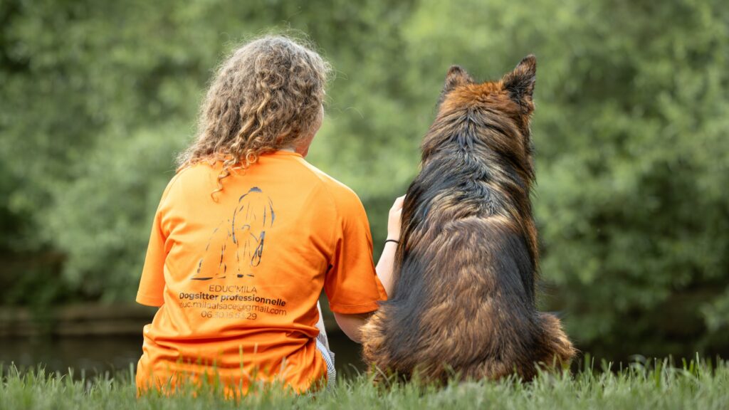 photographie d'un chien et son maître éducateur de dos