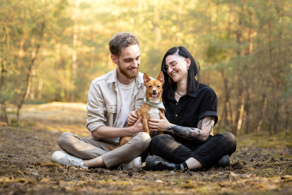photographie d'un couple avec son petit chien dans les bras dans une forêt en alsace