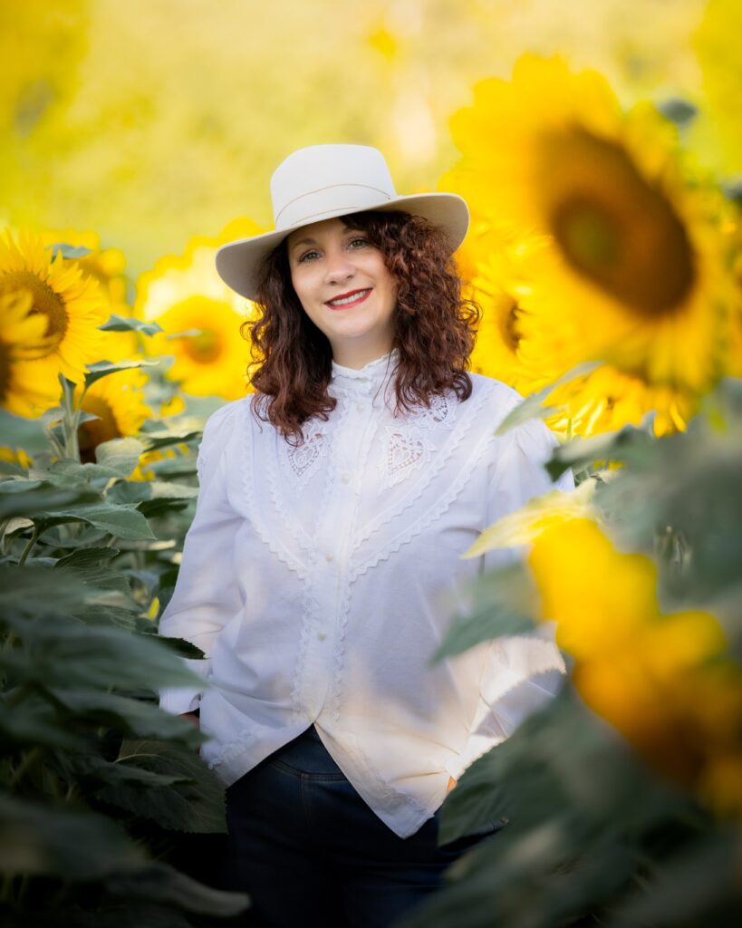 photographie d'une femme dans un champ de tournesol et son chapeau pour un portrait